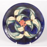 A Moorcroft pottery 'Holly Berries' pattern plate, shape 780, trial design, painted initials WM,