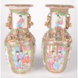 A pair of Chinese Canton porcelain vases, 19th century, with panels of figures in an interior scene,