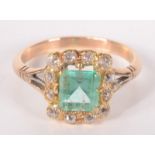 A 9ct gold ring, set a rectangular green stone surrounded by diamonds.