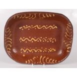 A earthenware slipware dish, 19th century, of rounded rectangular form, 25 x 32cm.