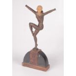 An Art Deco figure of a dancing lady, on a marble and slate demi lune base, indistinctly signed,