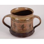 A Michael Cardew Winchcombe Pottery twin handled mug, decorated with stylised flowers,
