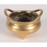 A Chinese polished bronze censer, 19th century, with twin handles and Xuande mark to base,