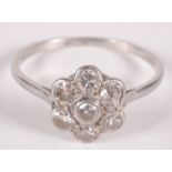 A diamond and platinum flowerhead cluster ring.