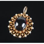 A good very high purity gold carbuncle pendant of pierced oval multi-lobed form,