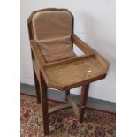 An Arts and Crafts oak child's high chair, with a rattan back and seat, height 95cm, width 36cm,