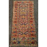 A Kurdish rug, the indigo field with four lozenge polychrome medallions,
