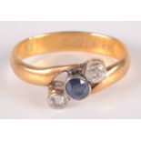 A 22ct gold crossover ring set two diamonds and a sapphire, 5g.