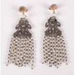 A pair of earrings, each with a diamond set palmettte from which hang strands of pearls.