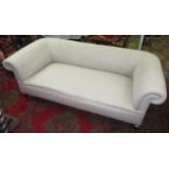 An oatmeal upholstered chesterfield sofa on square section tapering legs.