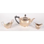 A half fluted silver teapot, a similar silver sugar bowl and cream jug, 20.5oz.