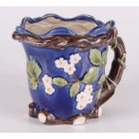 A Majolica jug, decorated with strawberry flowers, the handle modelled as a tree stump, height 15.
