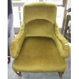A Victorian green upholstered armchair, the padded back, arms and seat on turned tapering legs.