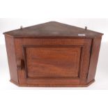 An inlaid mahogany corner cupboard, with a single panelled door, height 34.5cm, width 58.