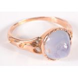 A high purity gold ring set a pale sapphire cabochon. Condition report: Size M.