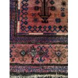 A Belouch rug, the central mihrab with stylised plants and guls within a hooked gul border,