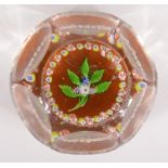 A mille fleur glass paperweight, the centre decorated with a leaf design,