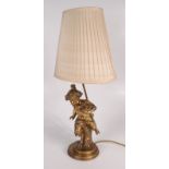 A gilt bronze table lamp, modelled as a child with cloven hooves, holding a bird's nest,