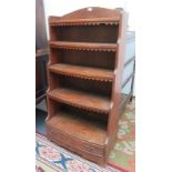 A bow front pine open bookcase, early 20th century, with five shelves above a single long drawer,