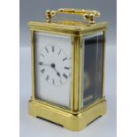 A brass carriage clock, the white enamelled dial with roman numerals, complete with winder,
