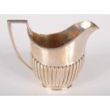 An Edwardian half fluted silver milk jug by Barnard, 5oz.