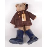 A Paddington Bear soft toy, with a brown hooded coat and blue wellington boots, height 55cm,