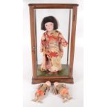 A Japanese porcelain and fabric doll, 20th century, dressed in a silk kimono,