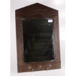 An Arts and Crafts rectangular ferrous sheet wall mirror, with a sunburst design to the top,