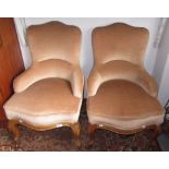 A pair of velvet upholstered small buttoned tub chairs, on cabriole legs with carved knees.