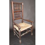 An early 19th century Lancashire spindle back chair with low open arms, rush seat and pad feet.