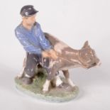 A Royal Copenhagen porcelain group of a boy and a calf,