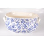 A blue and white floral decorated pottery foot bath,