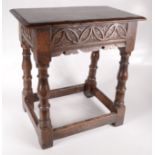 A carved oak joint stool in 17th century style.