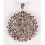 A rose cut diamond flowerhead pendant set in silver on low purity gold.
