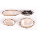 Four oval silver mounted brooches.