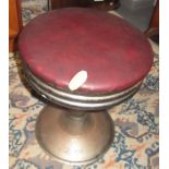 A chrome pedestal stool.