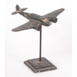 A green painted metal Mosquito on stand, height 20.5cm.
