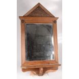 An Edwardian walnut wall mirror, with a rectangular bevelled plate above a single shelf,