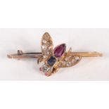 A high purity gold fly brooch set with diamonds, rubies and a sapphire.