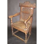 A 17th century carved oak joined chair with open arms, bobbin turned supports,