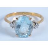 An 18ct gold and platinum ring, the central aquamarine flanked by diamonds.
