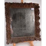 A small mirror with carved oak frame.