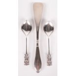 A pair of Arts and Crafts silver serving spoons with leaf shaped bowls and double lyre finials