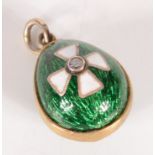 An enamelled egg in Russian style the green ground with an enamelled white Maltese cross centered