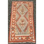 A Kelim rug, the grey field with rows of small stepped lozenge medallions,