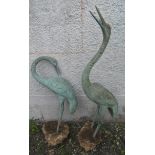 Two bronze garden ornaments in the form of cranes, heights 110cm and 78cm.