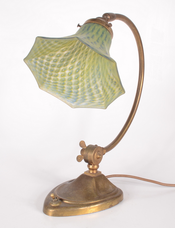 An Art Nouveau adjustable brass desk lamp, with a green and blue mottled flared glass shade,