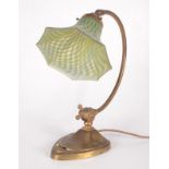 An Art Nouveau adjustable brass desk lamp, with a green and blue mottled flared glass shade,