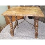 A Spanish hardwood side table, the carved rectangular top on turned legs,