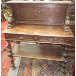 A Victorian carved oak buffet, the solid gallery back with scrolling vines and leaves,